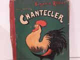 un vieux livre sur lequel figure un coq, posé sur une table