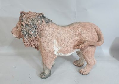 une statue de lion posée sur une surface blanche