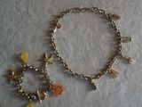silver bracelet with charms and charms on it on a white surface