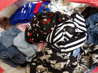 un panier rempli de vêtements posé par terre