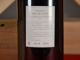 a bottle of wine sitting on a table with a wooden box in the background