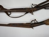 two old guns are displayed on a white surface