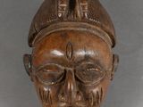 an image of a wooden mask hanging on a wall