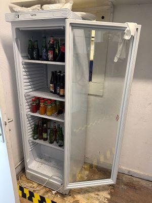 an image of a refrigerator in a room with a lot of bottles