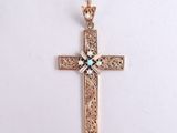 an image of a gold cross with a turquoise stone in the center