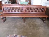 un banc en bois qui se trouve au milieu d'une pièce
