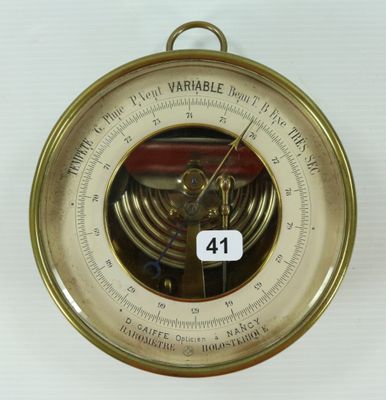 une horloge accrochée au mur, à laquelle est fixé un baromètre