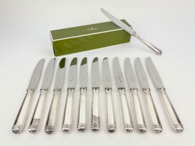 six knives and a box of knives sitting on a table