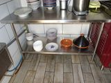 une table en acier inoxydable sur laquelle sont posés des bols et des casseroles