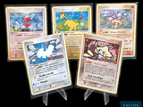 Quatre cartes Pokémon différentes sont représentées sur un fond noir.