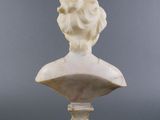 a white marble bust of a woman on a pedestal