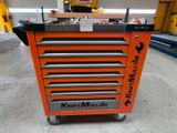 an orange tool cabinet with six drawers on wheels in a warehouse