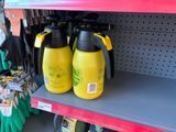 two yellow spray bottles sitting on a shelf in a store
