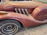 a rusted old car parked in a garage