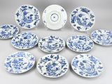 twelve blue and white plates with floral designs are arranged in a circle