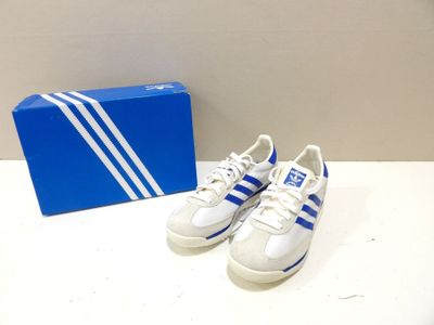 pair of white and blue adidas sneakers next to a blue box
