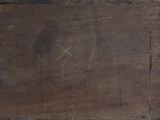a brown piece of wood that has some writing on it