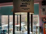 tables and chairs in a restaurant with a sign that says route 66 welcome to america