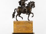 a bronze statue of a man on a horse on a marble base