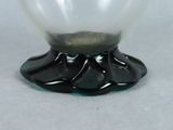 a glass bowl with a black base on a table