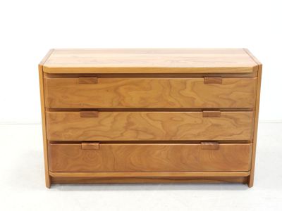 an image of a wooden chest of drawers on a white surface