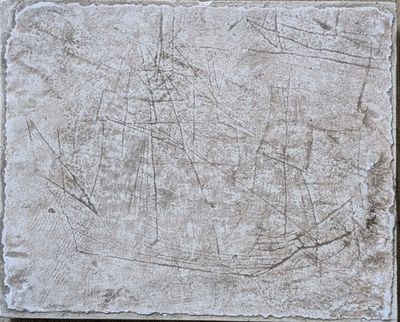 concrete slab with cracks and scratches on it on a wooden surface