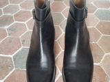 pair of black leather boots sitting on a brick floor