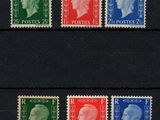un groupe de quatre timbres de couleurs différentes sur un fond noir