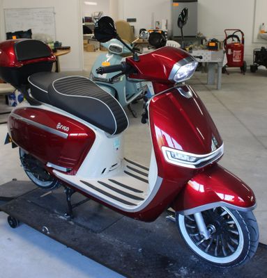 un scooter rouge et blanc garé dans un garage