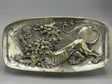 a silver plate with a lion and flowers on it