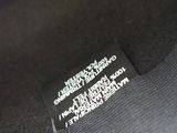 a close up of the label on the back of a black shirt