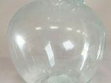 a clear glass vase with a handle on a table