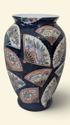 a blue vase with a fan design on it