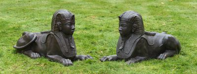 deux statues représentant un homme et une femme allongés dans l'herbe