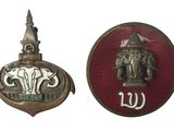 deux insignes métalliques représentant un éléphant et un bâtiment