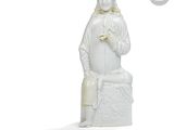 une statue blanche représentant une femme portant un chapeau et un sac