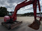 une pelleteuse rouge garée sur un parking