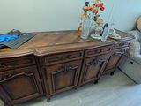 a dresser with a vase on top of it in a living room