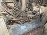un tas de vieux meubles dans une pièce où il y a beaucoup de bois
