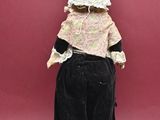 a doll of a woman in a black dress and bonnet