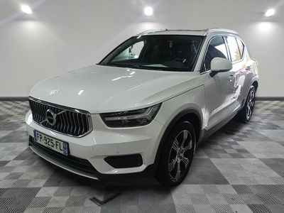Le SUV Volvo blanc est garé dans une grande pièce.