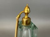 an image of a glass bottle with a gold handle on a table