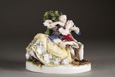 a figurine of a man and a woman sitting on a chair