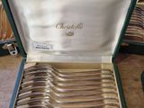 a lot of silverware in a green case on the table