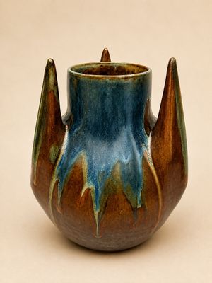 un vase bleu et marron posé sur une table