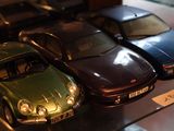 Plusieurs petites voitures sont exposées dans une vitrine.