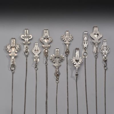 plusieurs types différents de colliers en argent posés sur un fond blanc