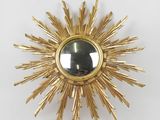 an image of a gold sunburst with a mirror in the middle