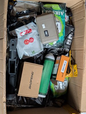 une boîte en carton remplie d'appareils électroniques et d'autres articles assortis