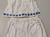 deux vêtements blancs avec des inscriptions bleues, posés sur une table